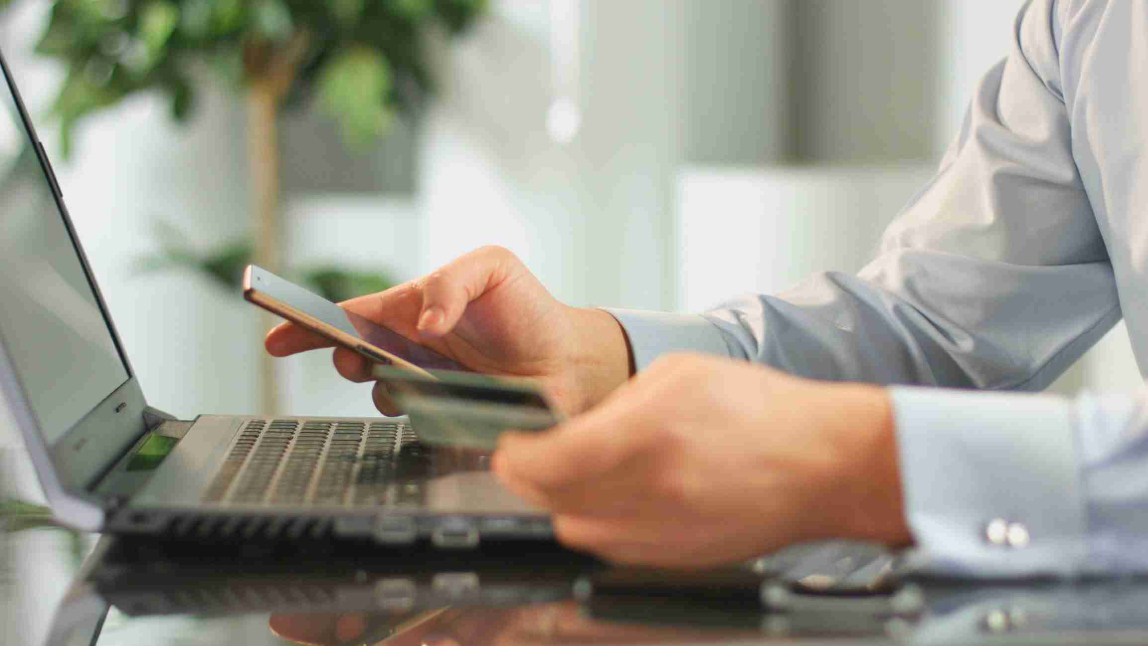 help with funeral costs in the uk - Man Making Online Payment From Bank Account, Using Mobile App On Smartphone