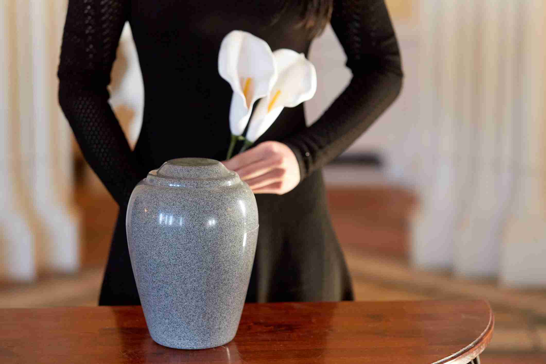 legal requirements after death - Woman With Cremation Urn At Funeral In Church