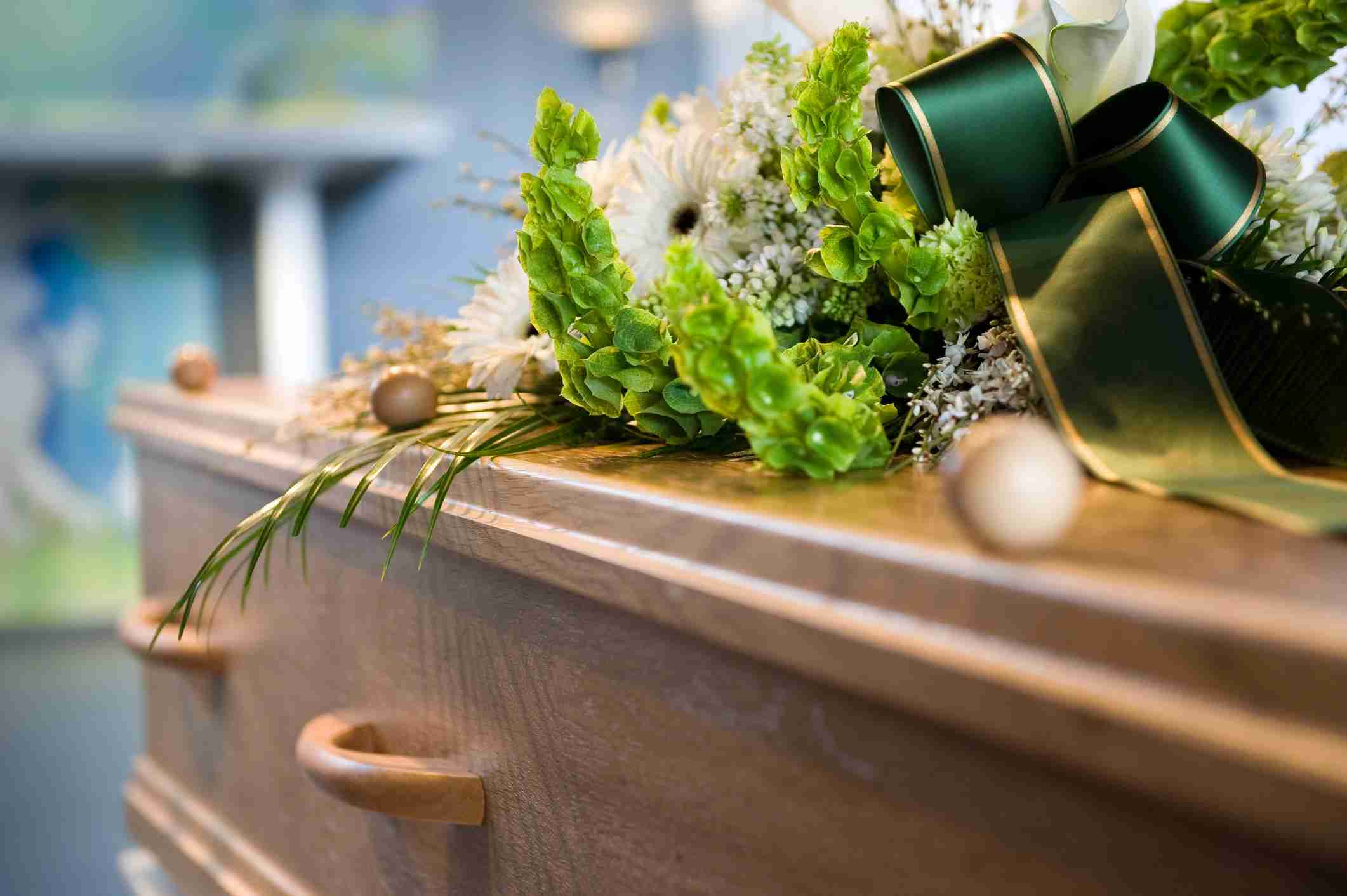 whats included in a direct cremation - A Coffin With A Flower Arrangement At A Mortuary